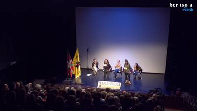 Mekatuan postua jartzen duen saltzailea eta bezeroa. Maialen Lujanbio eta Alaia Martin.